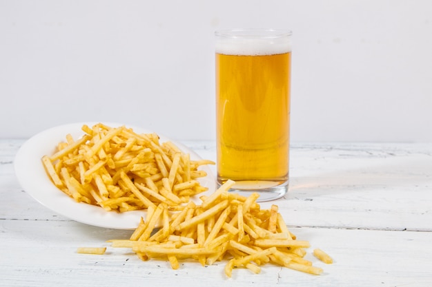 Stokken van frieten, bier en zout op witte plaat