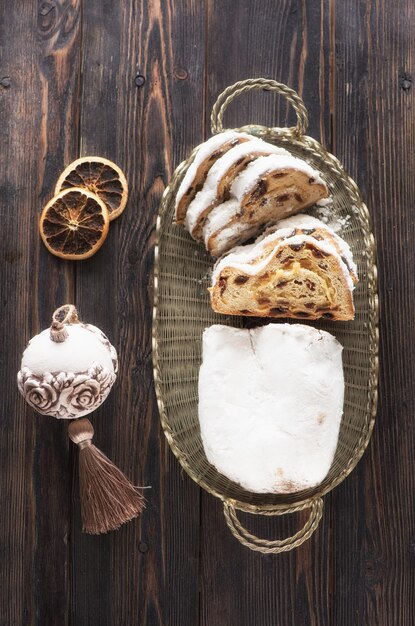 Stollen Christmas cake and New Year decorations, top view on wooden background