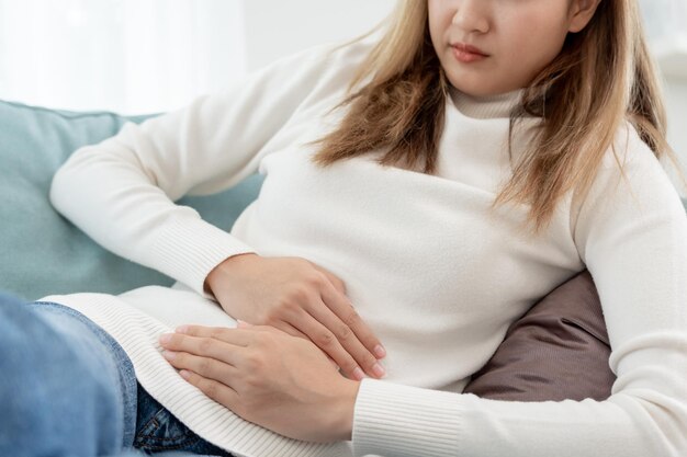 Foto mal di stomaco le donne asiatiche hanno dolori addominali indigestione gastrite crampi mestruali flatulenza diarrea distensione cancro al colon problemi di infiammazione della pancia soffrono di intossicazione alimentare addome