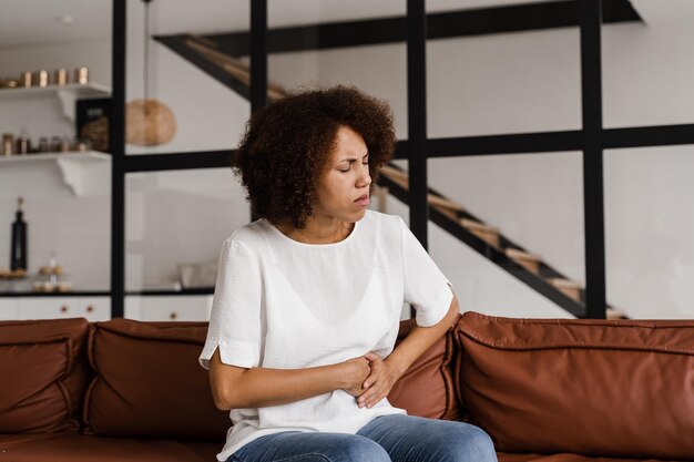 Foto mal di stomaco la ragazza afroamericana malata tiene l'addome perché fa male pancreatite la malattia del pancreas si infiamma