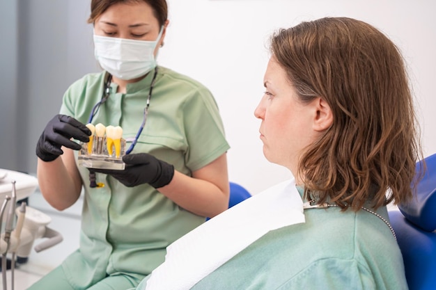 Стоматолог с пациентом обсуждает преимущества хирургии зубных имплантатов типов зубных имплантатов