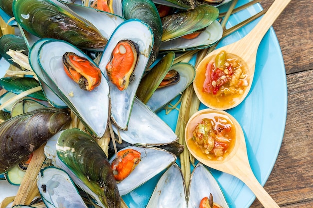 Foto stomende mossel met heerlijke saus op schotel met houten tafel zeevruchten stijl