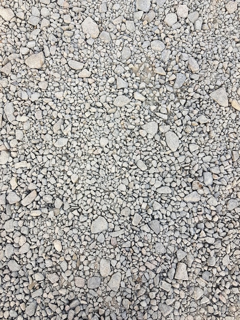 Photo stone background. gravel pebbles stone seamless texture, marble. dark background of crushed granite gravel, close up.