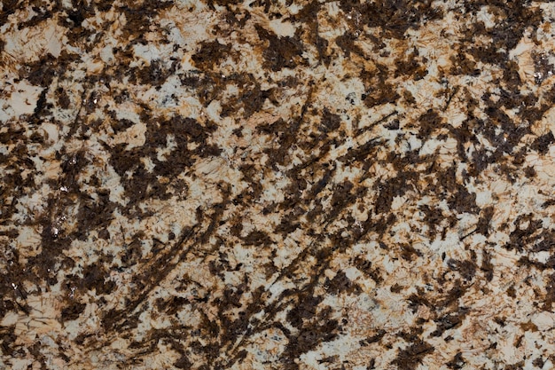 Stone background of mottled brown granite igneous rock