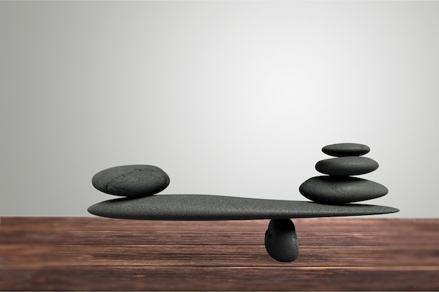 Stone Balance concept, black stone on wooden desk