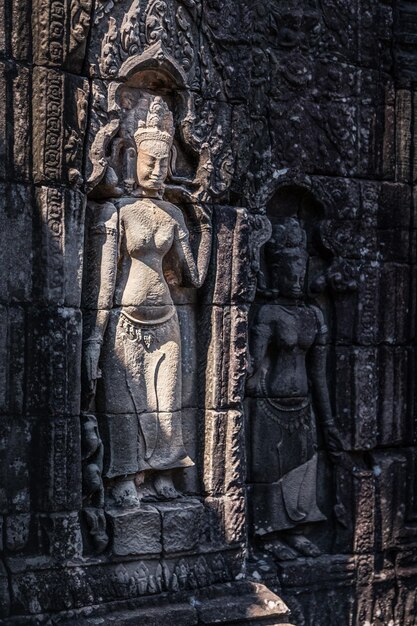 Stone basrelief of ancient Khmer goddess on the temple wall in Angkor complex Siem Reap Cambodia