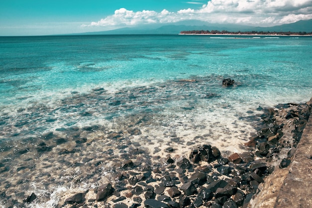 푸른 하늘이 있는 돌 해변 배경 Gili Trawangan