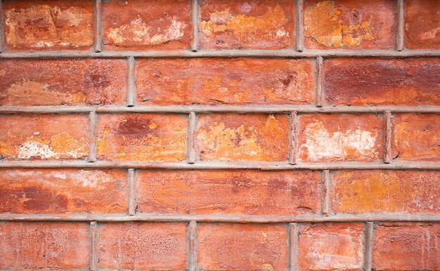 Stone brickwork facade of the building is orangered Background texture of old brick cladding