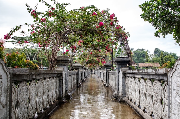 Stone bridge wet after rain decorated with flowers.