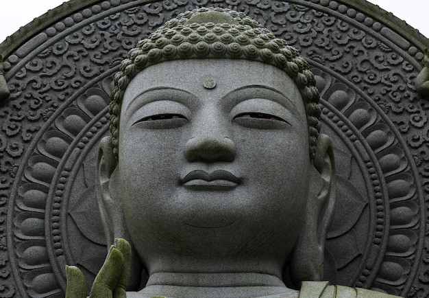 A stone buddha statue with the word buddha on the front.