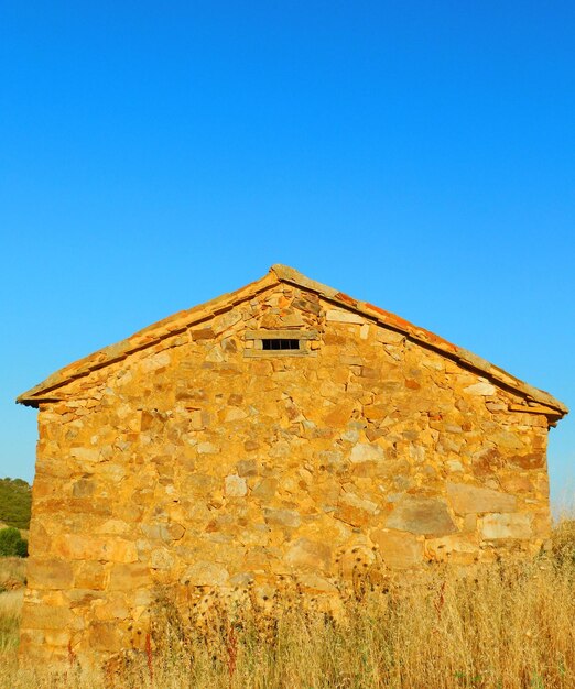 A stone building with a clear blue sky in the background