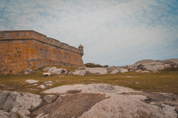 Foto un edificio in pietra con un muro di pietra e un cartello che dice 