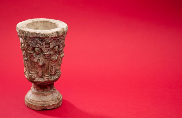 stone chalice with red background, space for text