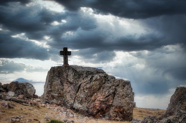 Foto croce di pietra con cielo nuvoloso