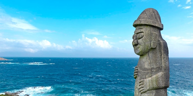 Photo stone dol hareubang in jeju island and panorama of sea in south korea