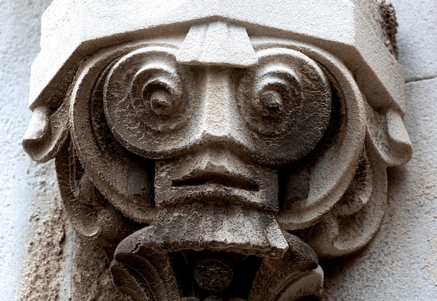 A stone face with a face on it is made of stone.