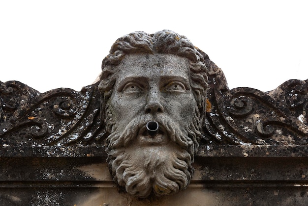 A stone face with a man's beard is surrounded by a pipe.