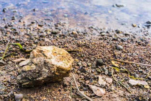 Stone on gravel background with focus at the top. Seashore.