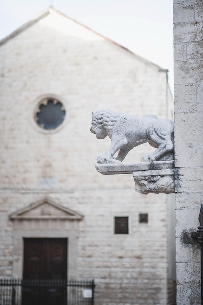 a stone lion statue is on a building with a clock above it