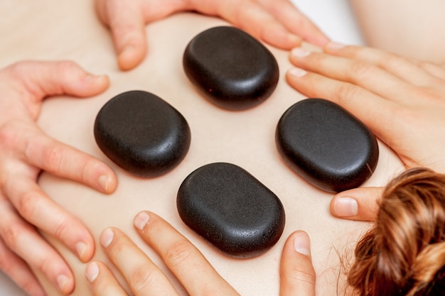 Stone massage on back of woman 