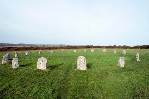 stone materials on grassy field against cloudy sky