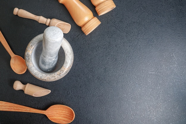 Stone mortar and wooden spoon for lights on the table top view, copy space