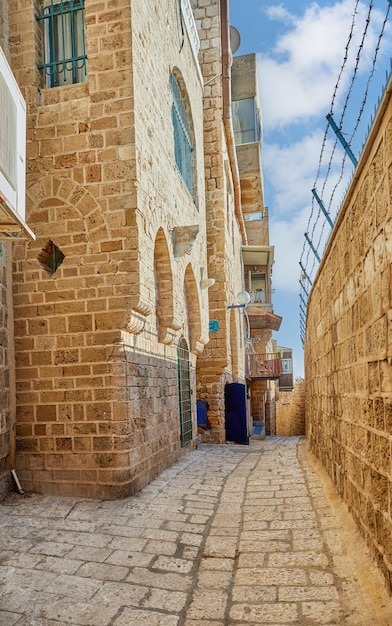 Stradine in pietra della città vecchia di jaffa contro il cielo blu con nuvole