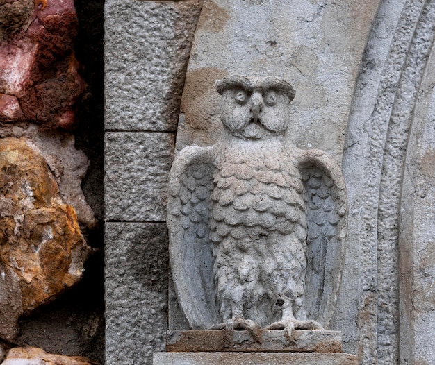 A stone owl statue with a stone face and a beak.