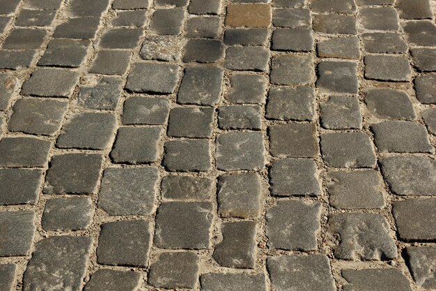 Stone pavement texture Granite cobblestoned pavement background Abstract background of old cobblestone pavement closeup Seamless texture