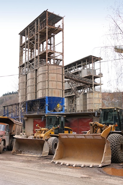 Stone quarry with silos conveyor belts and piles of stones
