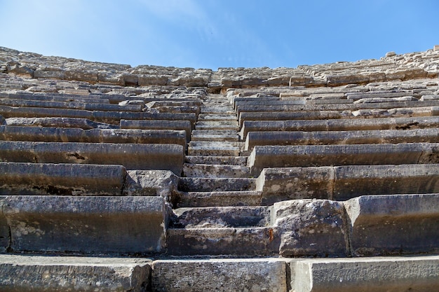 Stone steps of an old amphitheater from ancient times in the region of Antalya, Side, Turkey.