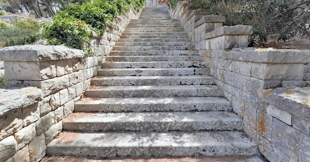 Stone steps of an outdoors straicase going up very high in a park of Puglia in Italy