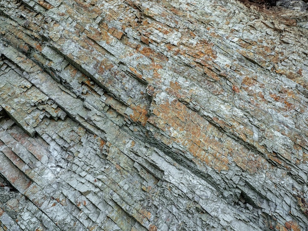 Stone texture. Cross section of rocks. Geological layers. Colored layers of stones in section of the mount, different rock formations and soil layers.