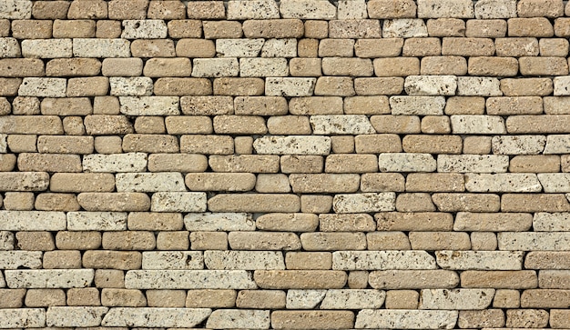 Stone wall or background, of natural rock of soft rock, sedimentary type. Gray travertine texture.