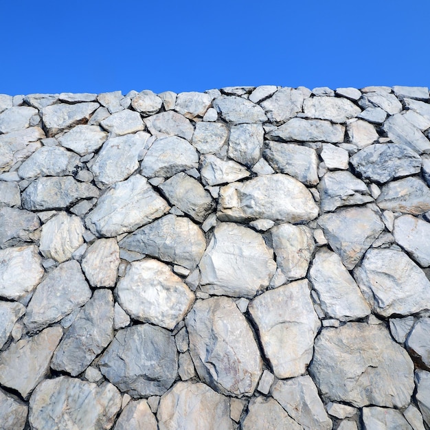 Фон и текстура каменной стены с голубым небом