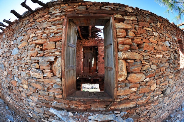 Foto muro di pietra e vecchia porta di legno rotta