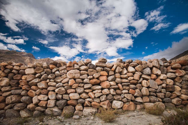 The stone wall constructed from the different sizes the boulders in grey brown tawny tints bright