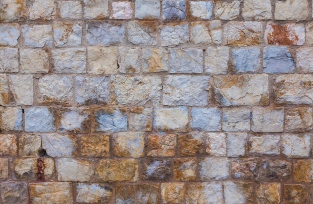 Stone wall made of natural stone Background of antique masonry