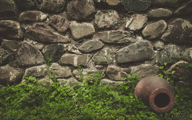 Stone wall texture background with ancient jar