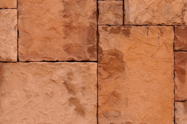 粗い砂岩のタイルと直線の接続で石の壁の質感