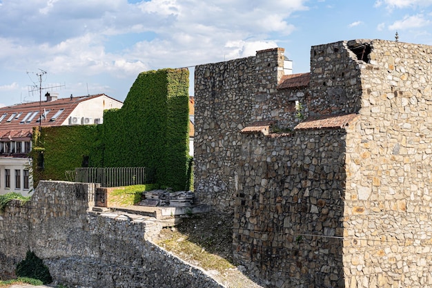 a stone wall with a building in the background