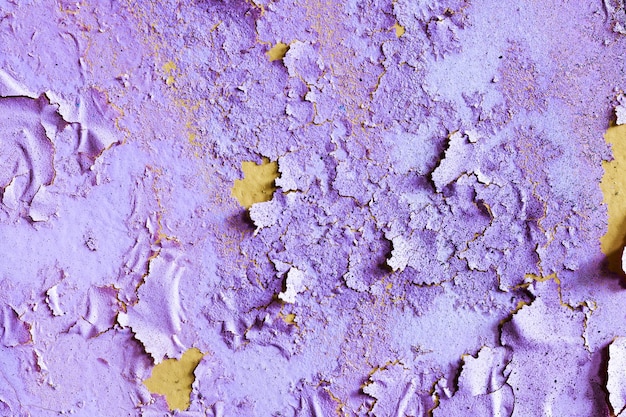 ひびの入った紫色のペンキが付いている石の壁。デザインの背景。グランジテクスチャ。高品質の写真