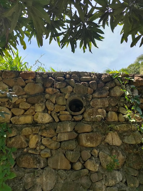 A stone wall with a hole in it