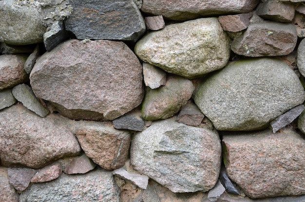 A stone wall with a large rock on it.