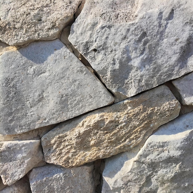 a stone wall with a shadow on it and a shadow on it