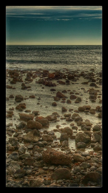 Foto pietre sulla spiaggia al crepuscolo