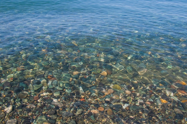 海の澄んだ水の中の石、水と石の背景
