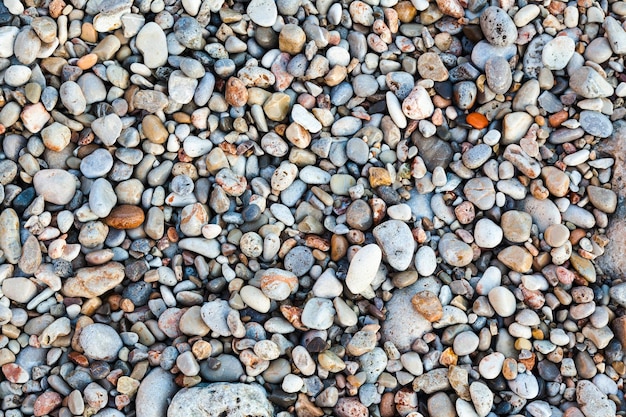 Photo stones of different shapes sizes and colors on the seashore closeup background of sea stones