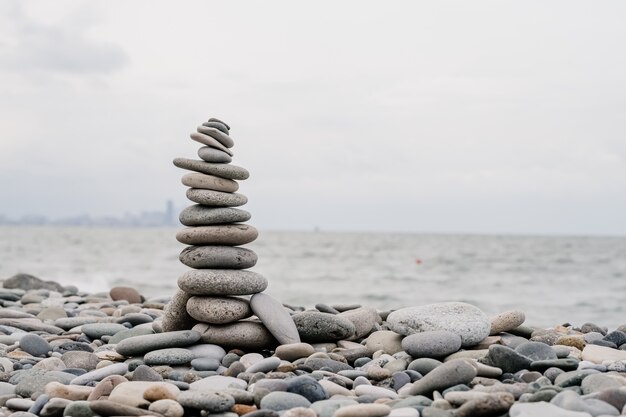 Фото Камни на пляже в форме пирамиды. баланс и медитация, место для текста