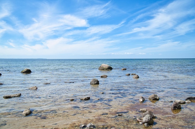 Камни и скалы на побережье Балтийского моря в морском пейзаже, снятом на солнце